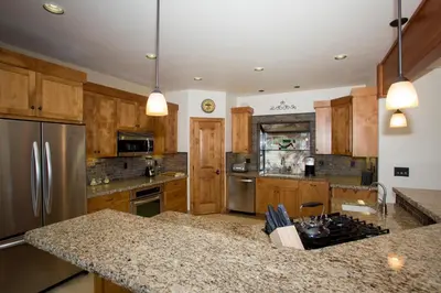 a kitchen with wooden cabinets and stainless steel appliances at Look Out Lodge - On North Shore w Lake View, Hot Tub, Pool Table and Pet Friendly in Kings Beach