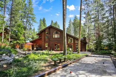 a wooden house in the woods with trees at Majestic Woods at Tahoe Donner - High End Craftsman w Game Room, Hot Tub, Amenity Access in Truckee