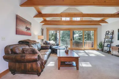 a living room with a leather couch and a table at Lupine Lodge at Tahoe Park on the West Shore - Hot Tub, Beach Access, Near Ski Resorts! in Tahoe City