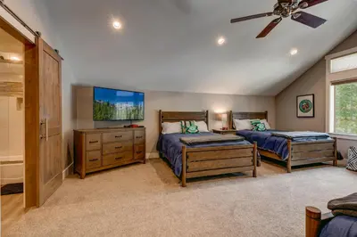 a bedroom with two beds and a flat screen tv at Mountain Jewel in Tahoe Donner - Beautiful 4 Bedroom w Hot tub, Access to HOA Amenities in Truckee