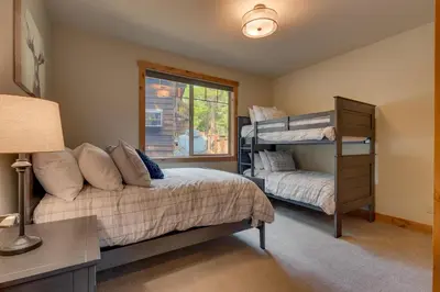 a bedroom with a bed and a bunk bed at Paradise in the Pines - Luxury Home in Quite Neighborhood, Wooded Views, Short Drive to Skiing in Carnelian Bay