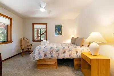 a bedroom with a bed and a table with a lamp at Shady Pines at Tahoe Donner- Serene Forest Retreat, 2 Gas Fireplaces, Sauna in Truckee