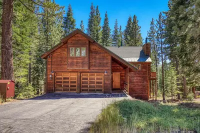 a log home with a garage in the woods at Shady Pines at Tahoe Donner- Serene Forest Retreat, 2 Gas Fireplaces, Sauna in Truckee