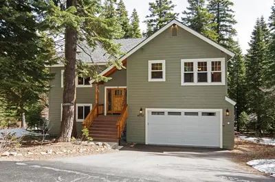 a green house with a white garage at Sans Souci Terrace on the West Shore- 4 BR Cabin, Avail as a Ski Lease, Near Skiing! in Homewood