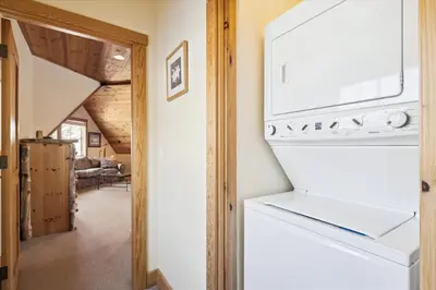 a kitchen with a white refrigerator and a living room at Silverado Lodge at Palisades - 4BR w Private Hot Tub & Ski Shuttle in Olympic Valley
