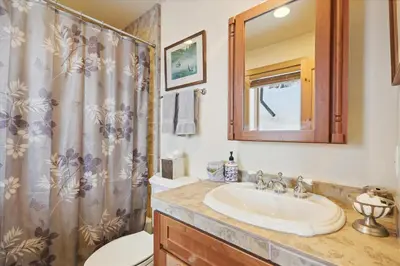 a bathroom with a sink and a toilet and a shower at Silverado Lodge at Palisades - 4BR w Private Hot Tub & Ski Shuttle in Olympic Valley