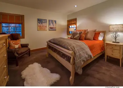 a bedroom with a bed and a chair at Skidder - Luxury 3500 sqft - Northstar 4BR w Game Room, Sauna, & HOA Amenities in Truckee