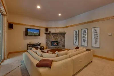 a living room with a large couch and a fireplace at Skislope Manor - Spacious Tahoe Donner 4 BR with Gorgeous Home Theater and Hot Tub in Truckee
