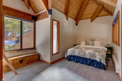 a bedroom with a bed and a large window at Snowbird Retreat at Northstar - Beautiful 4BR with Private Hot Tub, Free Ski Shuttle, HOA Amenities in Truckee