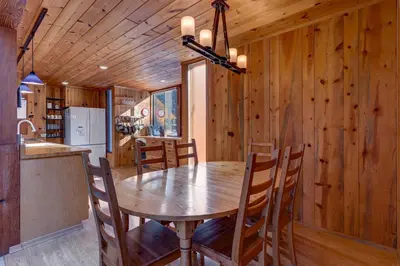 a kitchen and dining room with a wooden table and chairs at Snowbird Retreat at Northstar - Beautiful 4BR with Private Hot Tub, Free Ski Shuttle, HOA Amenities in Truckee
