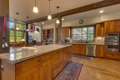 a large kitchen with wooden cabinets and a large island at Norse Hall in Tahoe Donner - Gorgeous Home with Private Hot Tub and Gourmet Kitchen in Truckee