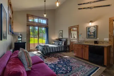 a living room with a purple couch and a kitchen at Norse Hall in Tahoe Donner - Gorgeous Home with Private Hot Tub and Gourmet Kitchen in Truckee