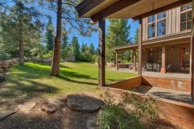 a house with a patio and a yard with trees at Norse Hall in Tahoe Donner - Gorgeous Home with Private Hot Tub and Gourmet Kitchen in Truckee