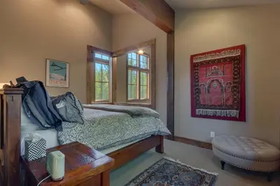 a bedroom with a bed and a table and window at Norse Hall in Tahoe Donner - Gorgeous Home with Private Hot Tub and Gourmet Kitchen in Truckee
