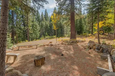 a park with benches and trees in the woods at High Altitude at Tahoe Donner - Huge 4 BR with Private Hot Tub, Pool Table, Ping Pong, HOA Amenities in Truckee