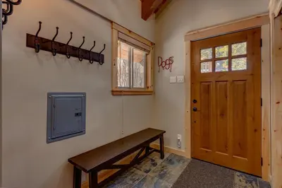 a room with a wooden bench next to a door at Edelweiss Retreat- Close to Lake and Ski Resorts- Pet Friendly- Hot Tub in Tahoe City