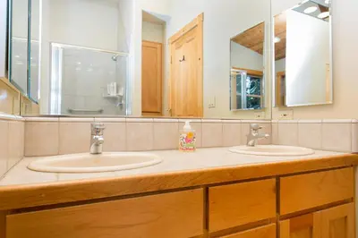 a bathroom with two sinks and a large mirror at Interlaken on the West Shore by Tahoe Getaways - Pet Friendly 3BR, Close to Skiing & Walk to the Lake! in Homewood