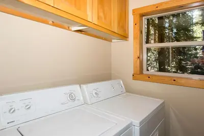 a laundry room with two washing machines and a window at Interlaken on the West Shore by Tahoe Getaways - Pet Friendly 3BR, Close to Skiing & Walk to the Lake! in Homewood
