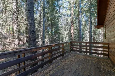 a wooden porch of a cabin in the woods at Interlaken on the West Shore by Tahoe Getaways - Pet Friendly 3BR, Close to Skiing & Walk to the Lake! in Homewood