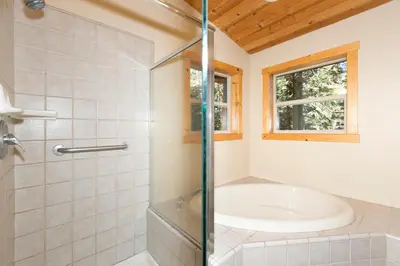 a bathroom with a tub and a glass shower at Interlaken on the West Shore by Tahoe Getaways - Pet Friendly 3BR, Close to Skiing & Walk to the Lake! in Homewood