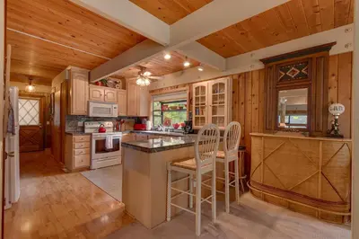 a kitchen with wooden walls and wooden floors at Cozy Wood Cabin- Updated- Hot Tub- Fireplace- Backs to Forest in Carnelian Bay