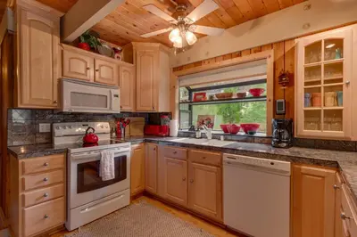 a kitchen with wooden cabinets and white appliances at Cozy Wood Cabin- Updated- Hot Tub- Fireplace- Backs to Forest in Carnelian Bay