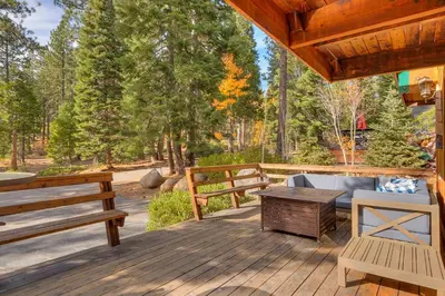 a wooden deck with two benches and a table at Cozy Wood Cabin- Updated- Hot Tub- Fireplace- Backs to Forest in Carnelian Bay