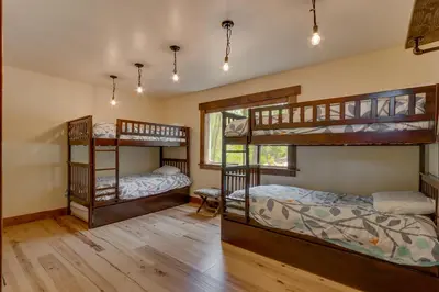 two bunk beds in a room with wooden floors at Hawk's Peak at Tahoe Donner in Truckee