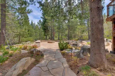 a stone walkway in a garden with trees at Hawk's Peak at Tahoe Donner in Truckee