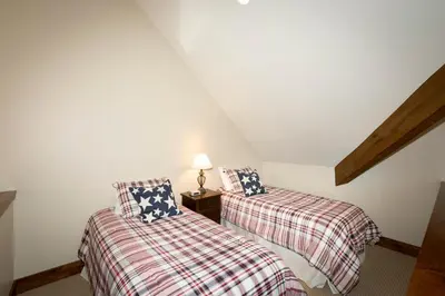 two twin beds in a attic room with a lamp at North Shore Bliss by Tahoe Getaways - 3 BR plus loft & Private Hot Tub in Carnelian Bay
