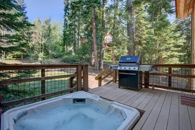 a hot tub on a deck with a grill at North Shore Bliss by Tahoe Getaways - 3 BR plus loft & Private Hot Tub in Carnelian Bay