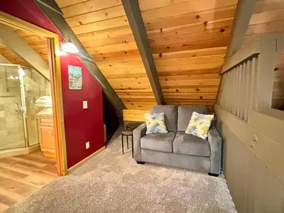 a living room with a chair and a red door at Piney wood - Quiet 2 BR Loft w Private Hot Tub in Carnelian Bay