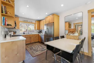 a kitchen with wooden cabinets and a table with chairs at Rustling Grove in Tahoe City - Pet-Friendly, Walking Distance to Downtown and Lake - Private Hot Tub in Tahoe City