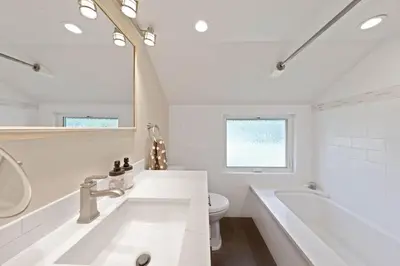 a white bathroom with a tub and a toilet at Rustling Grove in Tahoe City - Pet-Friendly, Walking Distance to Downtown and Lake - Private Hot Tub in Tahoe City