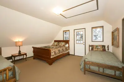 a attic bedroom with two beds and a window at Pineland Chalet in Tahoe City - Classic Cabin Wood Fireplace Dog Friendly in Tahoe City