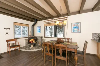 a dining room with a table and a fireplace at Pineland Chalet in Tahoe City - Classic Cabin Wood Fireplace Dog Friendly in Tahoe City