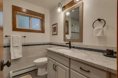 a bathroom with a toilet and a sink and a mirror at Silver Tip at Tahoe Park w HOA amenities - 3BR Pet Friendly, Hot Tub, Tahoe City in Tahoe City