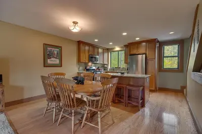 a kitchen with a wooden dining table and chairs at Silver Strike #2- Walk to Village- Ski Shuttle to Lifts in Truckee