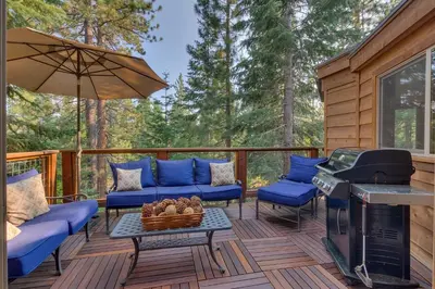 a deck with a grill and blue couches and a stove at Tahoe Rim Retreat - Spacious 4BR with Pool Table and Private Hot Tub - Pet Friendly! in Kings Beach