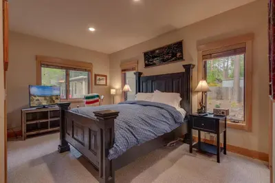 a bedroom with a bed and a flat screen tv at Tahoe Time on North Shore - 4 BR Cabin w Private Hot Tub, Pet Friendly, Walk to Dining in Tahoe Vista