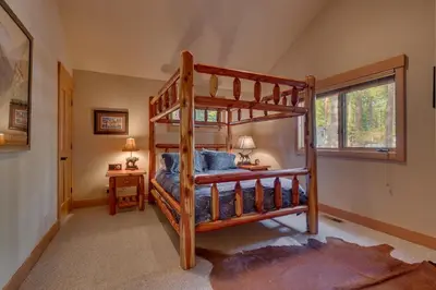 a bedroom with a bunk bed in a house at Tahoe Time on North Shore - 4 BR Cabin w Private Hot Tub, Pet Friendly, Walk to Dining in Tahoe Vista