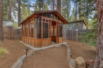 a wooden house in the middle of a forest at Tahoe Time on North Shore - 4 BR Cabin w Private Hot Tub, Pet Friendly, Walk to Dining in Tahoe Vista