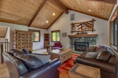 a living room with leather furniture and a fireplace at Tahoe Woods by Tahoe Getaways - Pet Friendly Tahoe Park Cabin w Hot Tub, Fireplace, Near Skiing! in Tahoe City