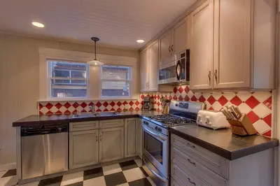 a kitchen with wooden cabinets and a stove top oven at Vanni House - Classic Tahoe Style 2 BR - Sleeps 6 - Hot Tub - Near Palisades & Downtown Tahoe City in Tahoe City