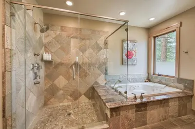 a bathroom with a tub and a glass shower at Truckee Timbers at Gray's Crossing by Tahoe Getaways - 4BR w Hot Tub, Ping Pong & EV in Truckee