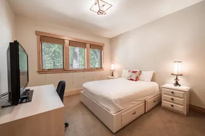 a bedroom with a bed and a desk with a television at Truckee Timbers at Gray's Crossing by Tahoe Getaways - 4BR w Hot Tub, Ping Pong & EV in Truckee