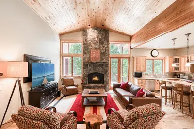a living room with a couch and a fireplace at Truckee Timbers at Gray's Crossing by Tahoe Getaways - 4BR w Hot Tub, Ping Pong & EV in Truckee
