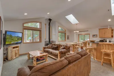 a living room with a large couch and a kitchen at Tahoma Charm on West Shore - Beautiful Open Concept 3 BR w Private Hot Tub in Tahoma