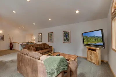 a living room with a couch and a flat screen tv at Tahoma Charm on West Shore - Beautiful Open Concept 3 BR w Private Hot Tub in Tahoma