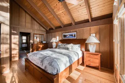 a bedroom with a bed and a wooden wall at View at Dollar Point - Beautiful Lake Views with Sunny Deck, Quiet Neighborhood, Near Skiing in Tahoe City